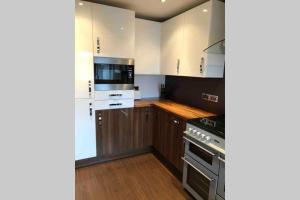 a kitchen with white cabinets and a stove top oven at Modern 3 bedroom home close to Wareham Forest in Wareham