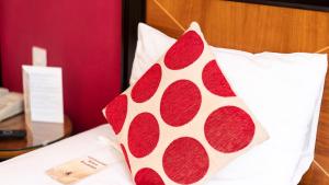 a red and white pillow sitting on top of a bed at Britannia Hotel Newcastle Airport in Newcastle upon Tyne