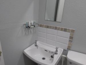 a bathroom with a sink and a toilet and a mirror at Haven Inn in Barrow upon Humber