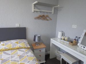 Habitación pequeña con cama y escritorio. en Haven Inn en Barrow upon Humber