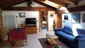 a living room with a blue couch and a tv at Nel Verde in Villar San Costanzo