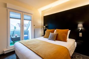 a bedroom with a large bed with a large window at Europe Haguenau – Hotel & Spa in Haguenau