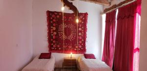 a room with two beds and a red curtain at Hotel Hacienda Casa Blanca in Tinogasta