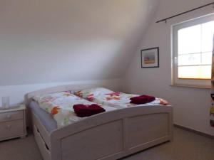 a bedroom with a bed in a room with a window at Reetdachhaus Sonnenschein in Mursewiek