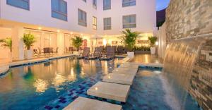 圣玛尔塔Del Mar Hotel的建筑物前的游泳池