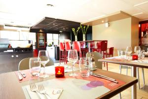 ケサルグにあるカンパニール ニーム シュド - ケサルグのワイングラス付きのテーブルと椅子のあるレストラン