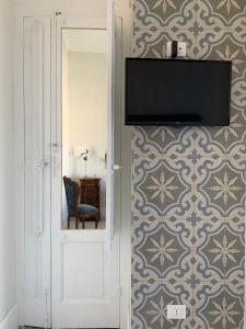 ein Flachbildfernseher an der Wand in einem Zimmer in der Unterkunft Palazzo Samà in Catanzaro