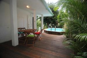 a patio with a table and a swimming pool at Le Frangipanier Villa avec piscine in Saint-Denis