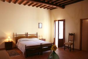a bedroom with a bed and a chair at Fattoria Le Chianacce in Cortona