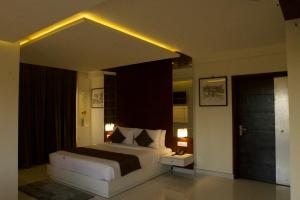 a bedroom with a large bed with lights on it at Boon Inn in Malappuram +14 photos