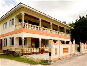 uma casa grande com uma varanda ao lado em Villa Bananier em Baie Sainte Anne