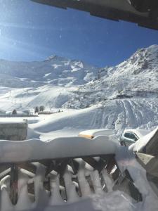 una montaña cubierta de nieve con un coche aparcado en una carretera en Résidence moudang 2 Pied de piste, en Aragnouet