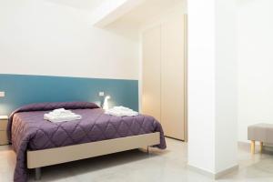 a bedroom with a purple bed with a blue headboard at Razione K Appartamenti & SPA in Casal Velino +81 photos