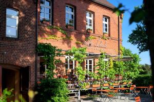 ein Backsteingebäude mit Tischen und Stühlen davor in der Unterkunft Alte Schule Reichenwalde in Reichenwalde