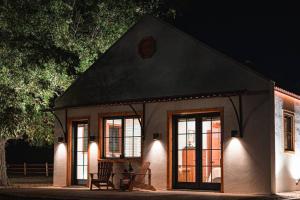 Little Dutch Cabin #3 - 12 min to Magnolia-Baylor في Bellmead: منزل أبيض صغير مع نوافذ في الليل