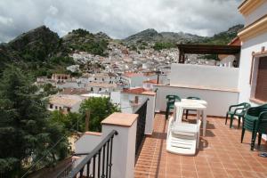 balcón con sillas y vistas a la ciudad en Apartamentos Sierra del Hacho, en Montejaque