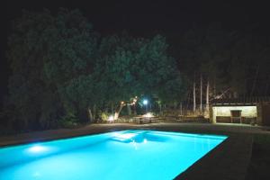 uma grande piscina azul à noite em Casa rural Mas del Serranet em Horta de San Joan