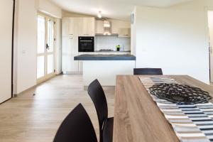 a kitchen and dining room with a wooden table and chairs at Razione K Appartamenti & SPA in Casal Velino