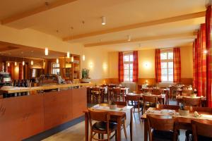 a restaurant with tables and chairs in a room at Alte Schule Reichenwalde in Reichenwalde