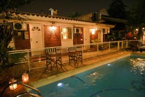 a house with a swimming pool at night at Bernie's Bed & Breakfast , A 3 KILOMETROS DEL AEROP EZEIZA, VAN ,IN-OUT, FREE EZEIZA AIRPORT in Ezeiza