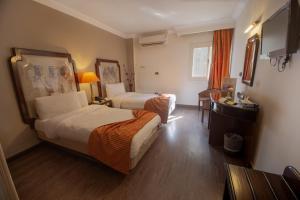 a hotel room with two beds and a desk at Zayed Hotel in Cairo +68 photos