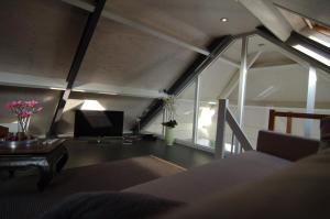 een woonkamer met een bank, een tv en een tafel bij Gardenhouse with private jacuzzi and sauna in Teteringen