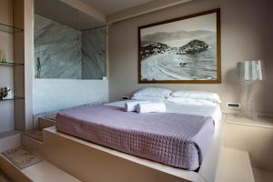 a bedroom with a bed with a picture on the wall at Fenetre sur le blue in Taormina