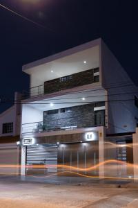 un bâtiment la nuit avec une voiture qui passe devant lui dans l'établissement Apartamentos Torre II Condominios - Pet Friendly, à Mazatlán