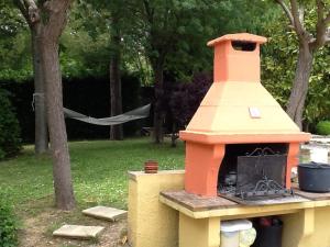 un horno al aire libre con chimenea en un patio en Il Giardino Dei Limoni, en Montecassiano