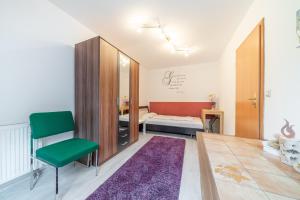 een kamer met een bed en een groene stoel bij Private Rooms in Hannover