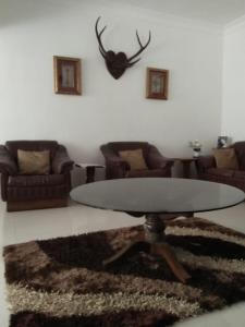 a living room with a table and some couches at Kwality Estate in Madikeri