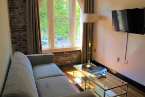 a living room with a couch and a tv at Hotel Hale in Hot Springs
