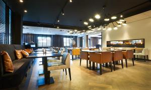 a restaurant with tables and chairs and a bar at Postillion Hotel Dordrecht in Dordrecht