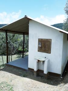 a white building with a sink and a window at Camping Avohai in São Thomé das Letras