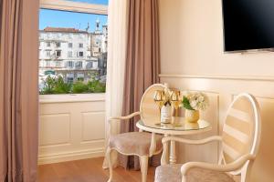 um quarto com uma mesa e duas cadeiras e uma janela em Piazza Heritage Hotel em Split