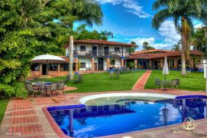 una casa con piscina frente a un patio en Hotel Bosques Del Saman Alcala, en Quimbaya