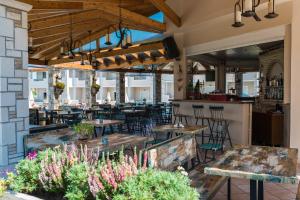 a restaurant with tables and chairs and a bar at Windmill Hotel in Argassi