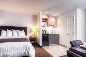 Una habitación de hotel con una cama y una cocina. en Hotel Vacances Tremblant, en Mont-Tremblant