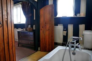 uma casa de banho com banheira e uma porta de madeira em Rhydspence em Hay-on-Wye