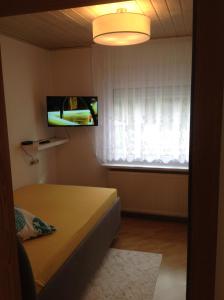 una piccola camera con letto e televisore di FeWo König a Milbitz