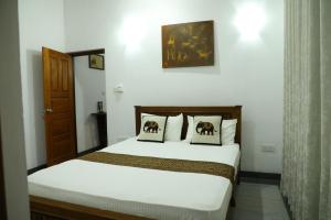 1 dormitorio con 1 cama con 2 almohadas en Kandy Wellington Apartment en Kandy