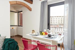 una sala da pranzo con tavolo bianco e sedie rosse di Casa Cosi - Maria Novella a Firenze