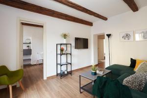 a living room with a green couch and a table at Casa Cosi - Maria Novella in Florence