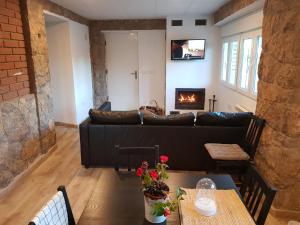 - un salon avec un canapé et une cheminée dans l'établissement Apartament Vall de Montserrat, à Castellbell i Vilar