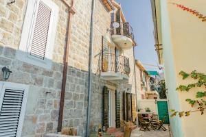 an alley in an old building with a balcony at Apartments Bigovo Veljic in Tivat