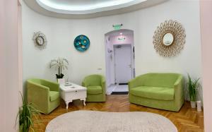 una sala de espera con 2 sillas verdes y una mesa en Victoria Luxury Apartment 11, en Bucarest