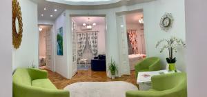 1 dormitorio y sala de estar con 2 sillas verdes. en Victoria Luxury Apartment 11, en Bucarest