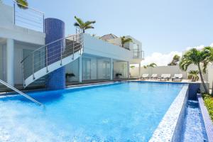 a swimming pool in front of a house at Ocean Z Boutique Hotel in Palm-Eagle Beach
