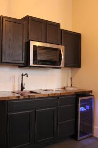 uma cozinha com armários pretos e um micro-ondas em Eighteen-Ninety Sleepover em Casey