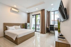 a bedroom with a bed and a desk and a television at ViVo 416 Apartment in Ho Chi Minh City